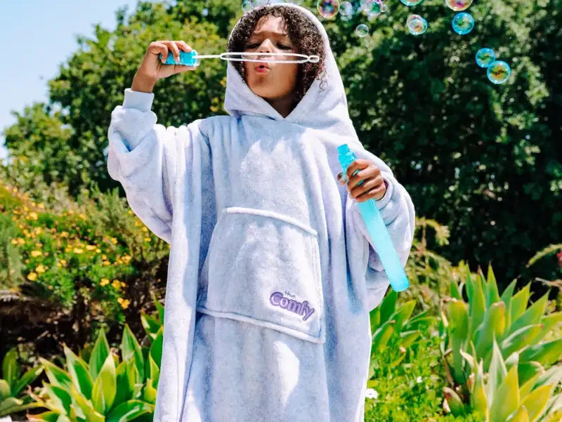 kid blowing bubbles, wearing The Comfy