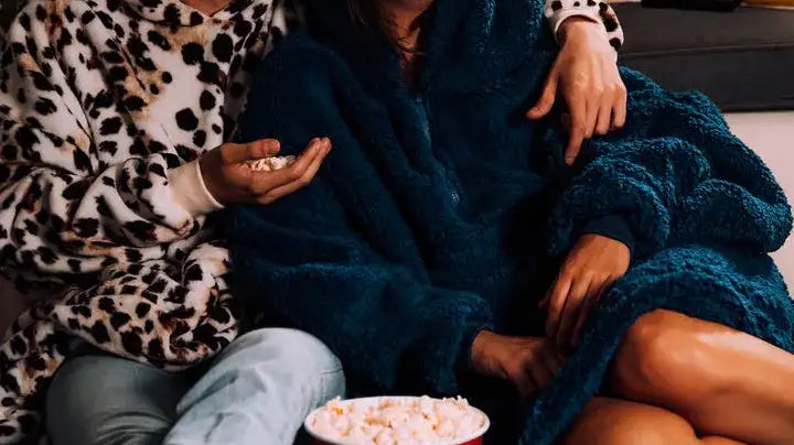 man and woman watching a movie and eating popcorn