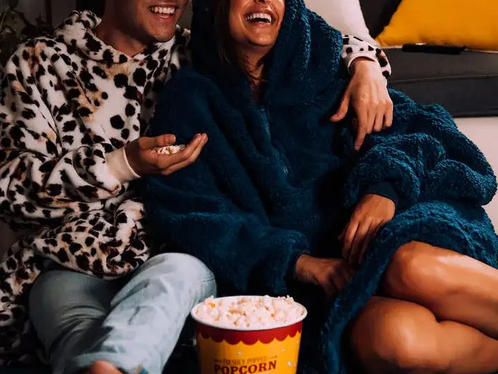 man and woman watching a movie and eating popcorn
