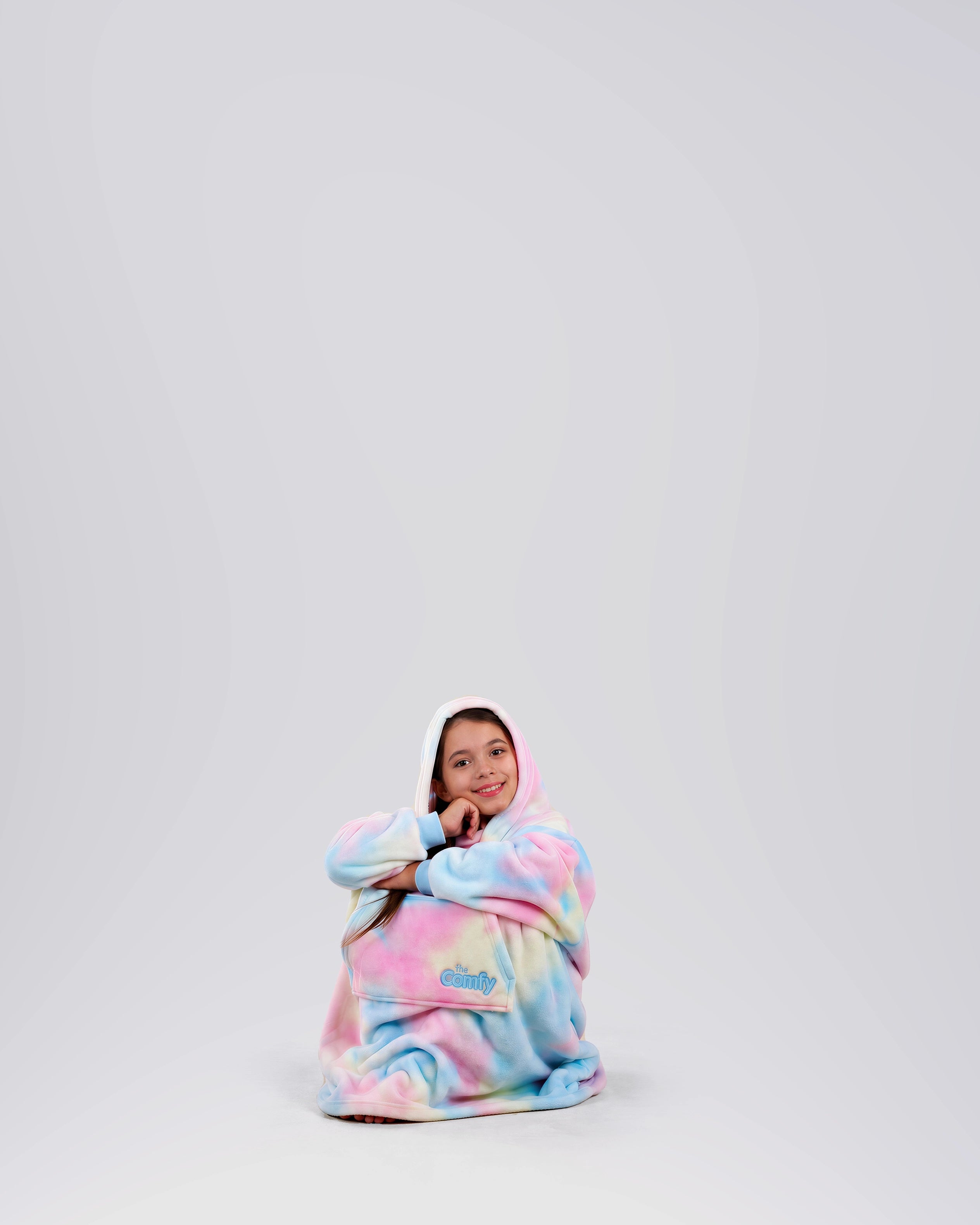 Child sitting comfortably in The Dream Jr. in Cotton Candy Tie Dye, showing its soft drape and relaxed fit.