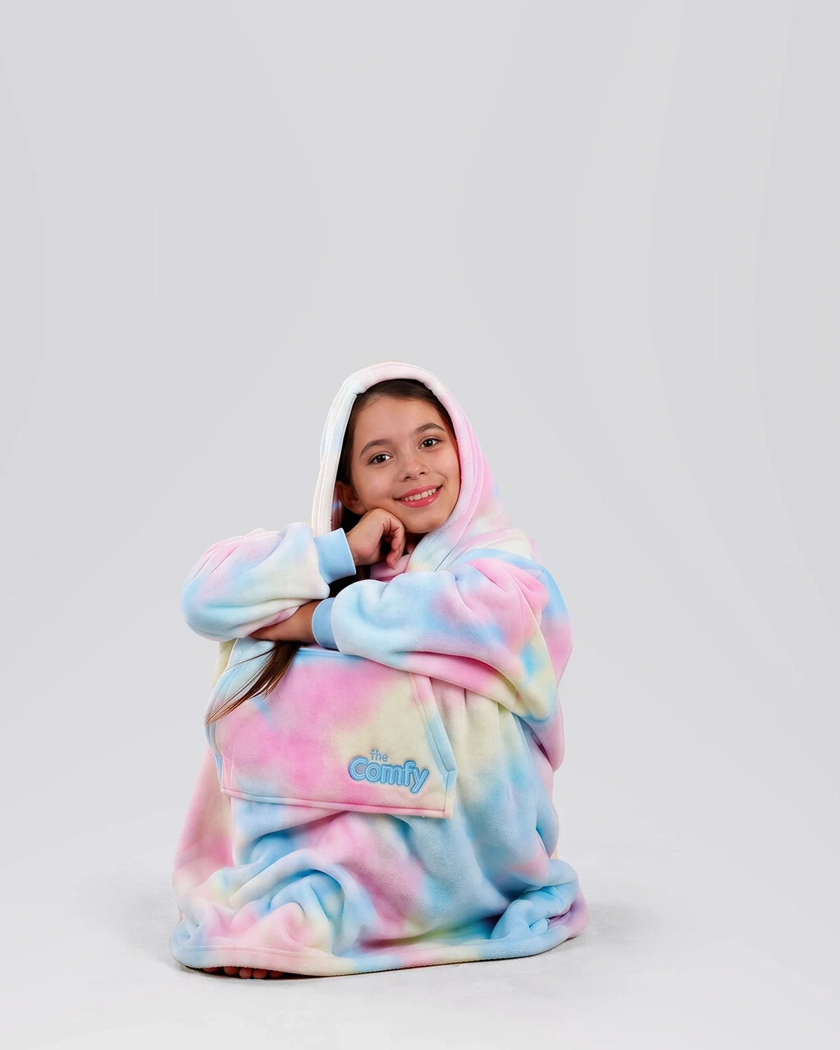 Child sitting comfortably in The Dream Jr. in Cotton Candy Tie Dye, showing its soft drape and relaxed fit.