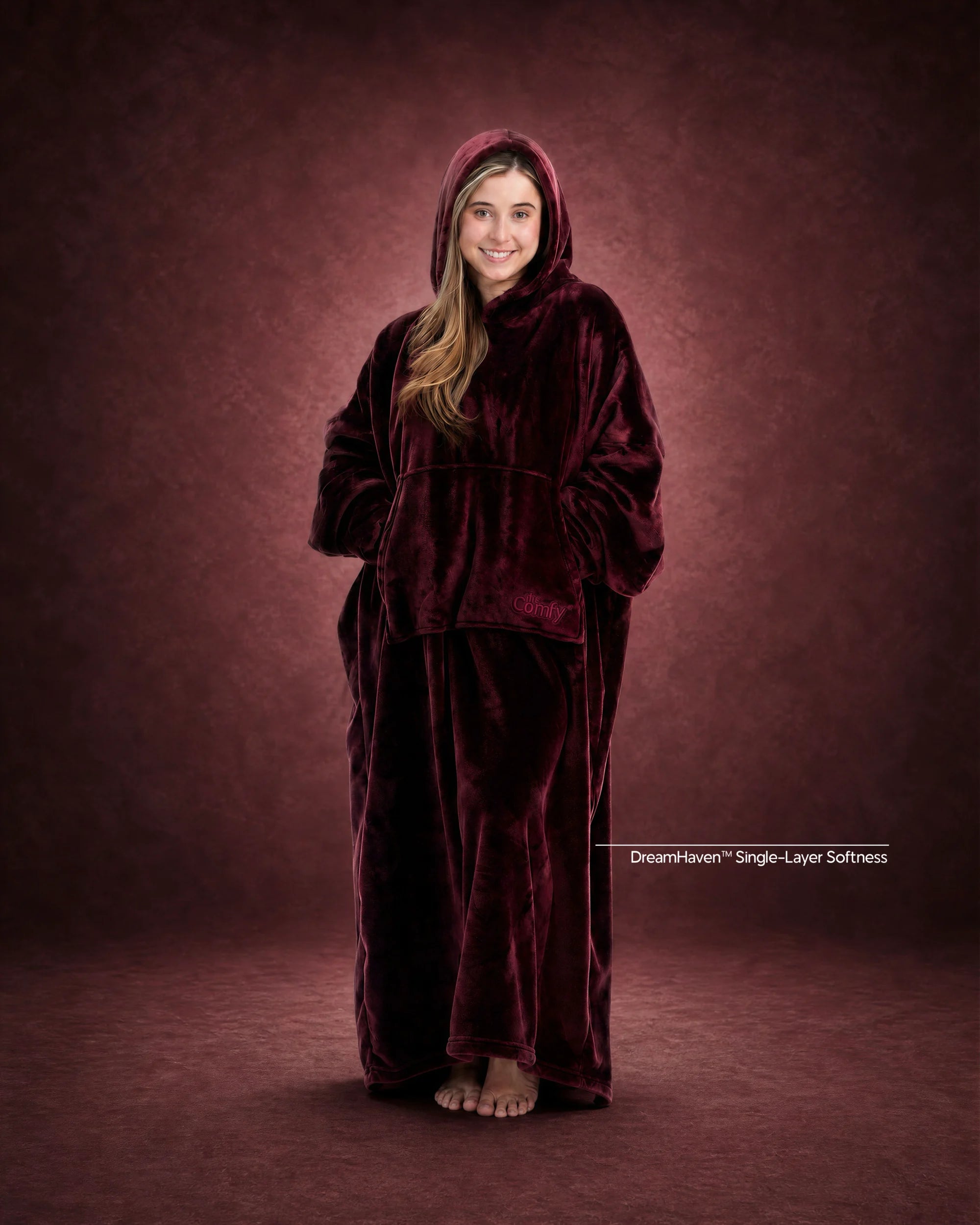 Woman standing in The Dream Long wearable blanket in Burgundy, showcasing the floor-length design and oversized fit.