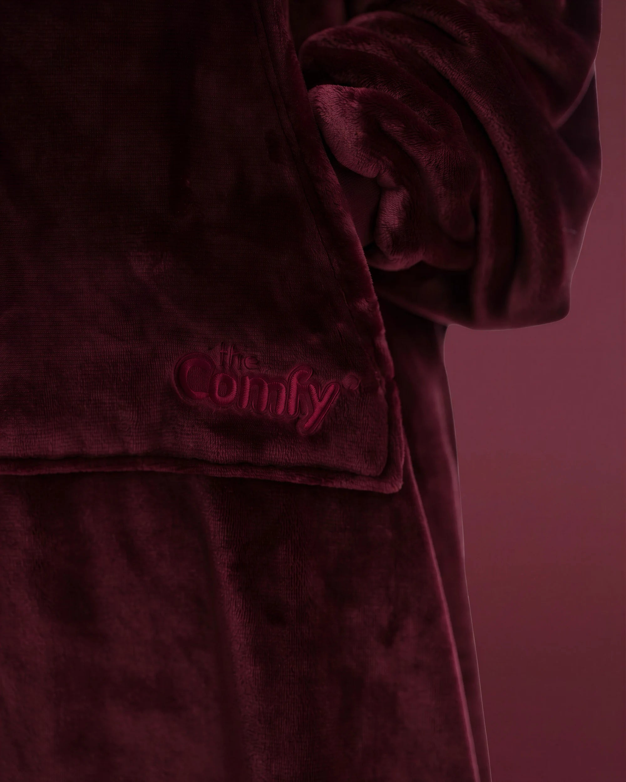 Close-up of The Dream Long in Burgundy featuring the soft microfiber fabric, front pocket, and embroidered The Comfy logo.