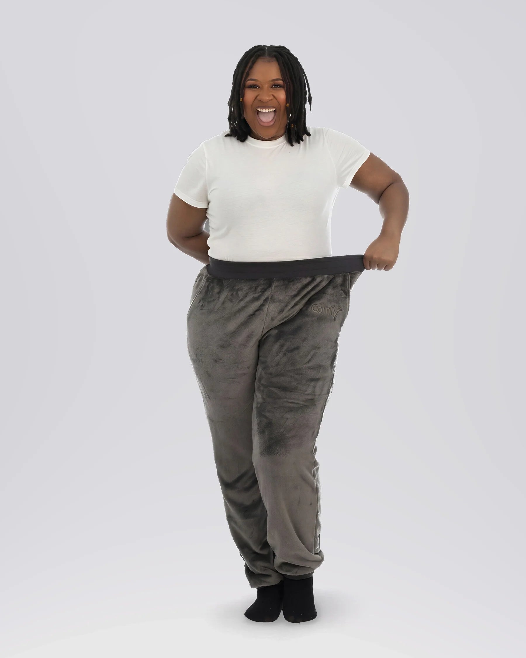 Woman stretching the waistband of Dream Pants in Dark Gray, highlighting the relaxed fit, soft Dream fabric, and comfortable elastic waistband.