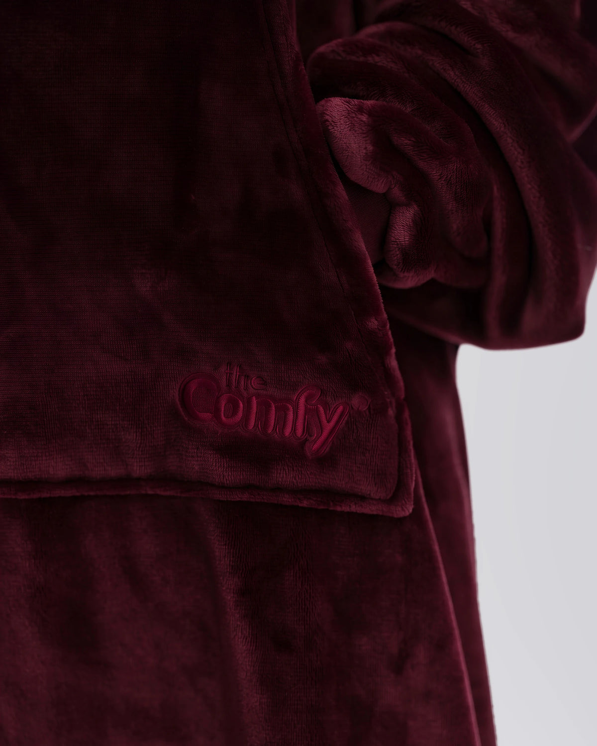Close-up of The Dream in Burgundy showing its fabric and embroidered logo.