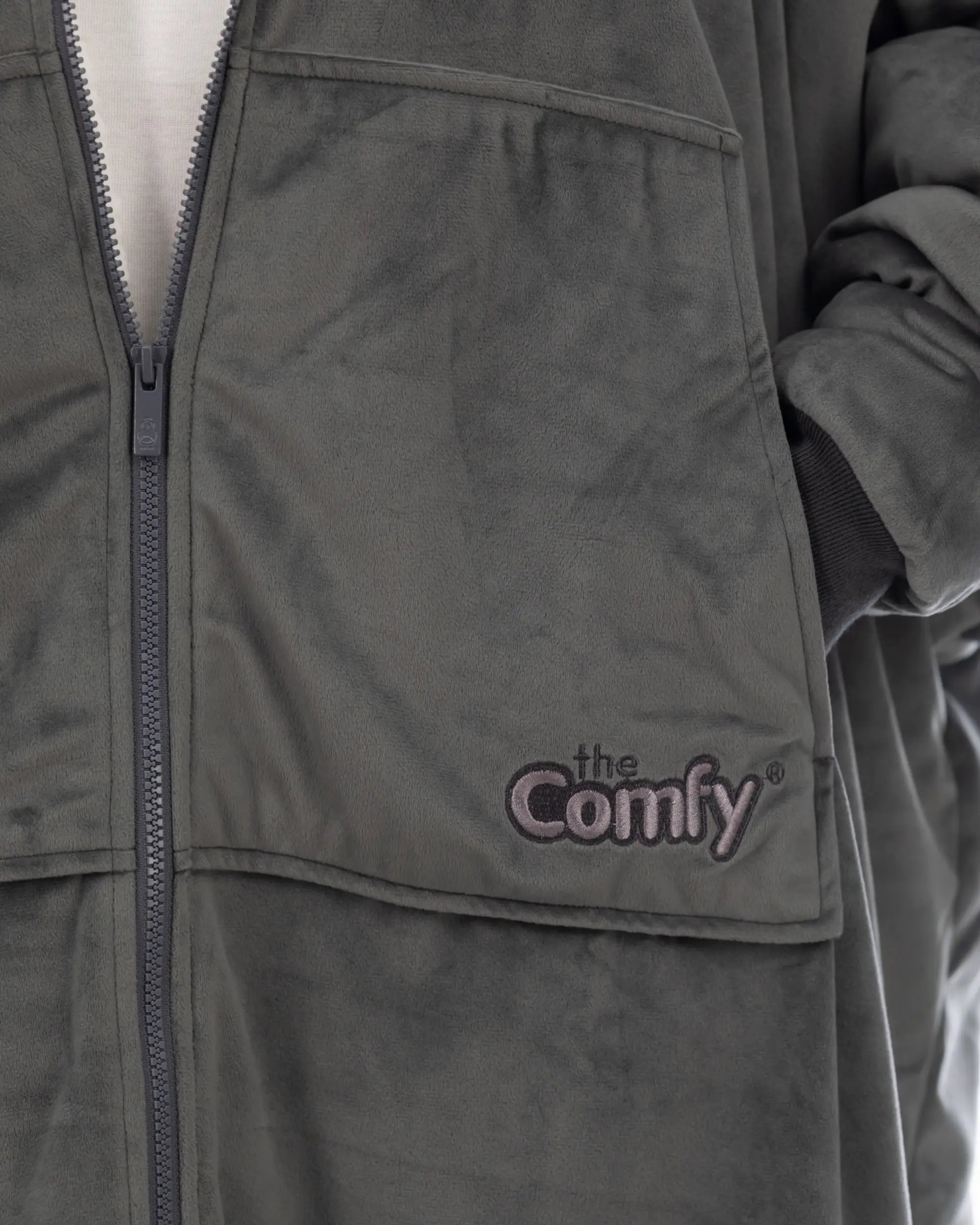 Close-up of The Original Full-Zip wearable blanket in charcoal showing zipper detail, Velveluxe™ exterior, and embroidered logo