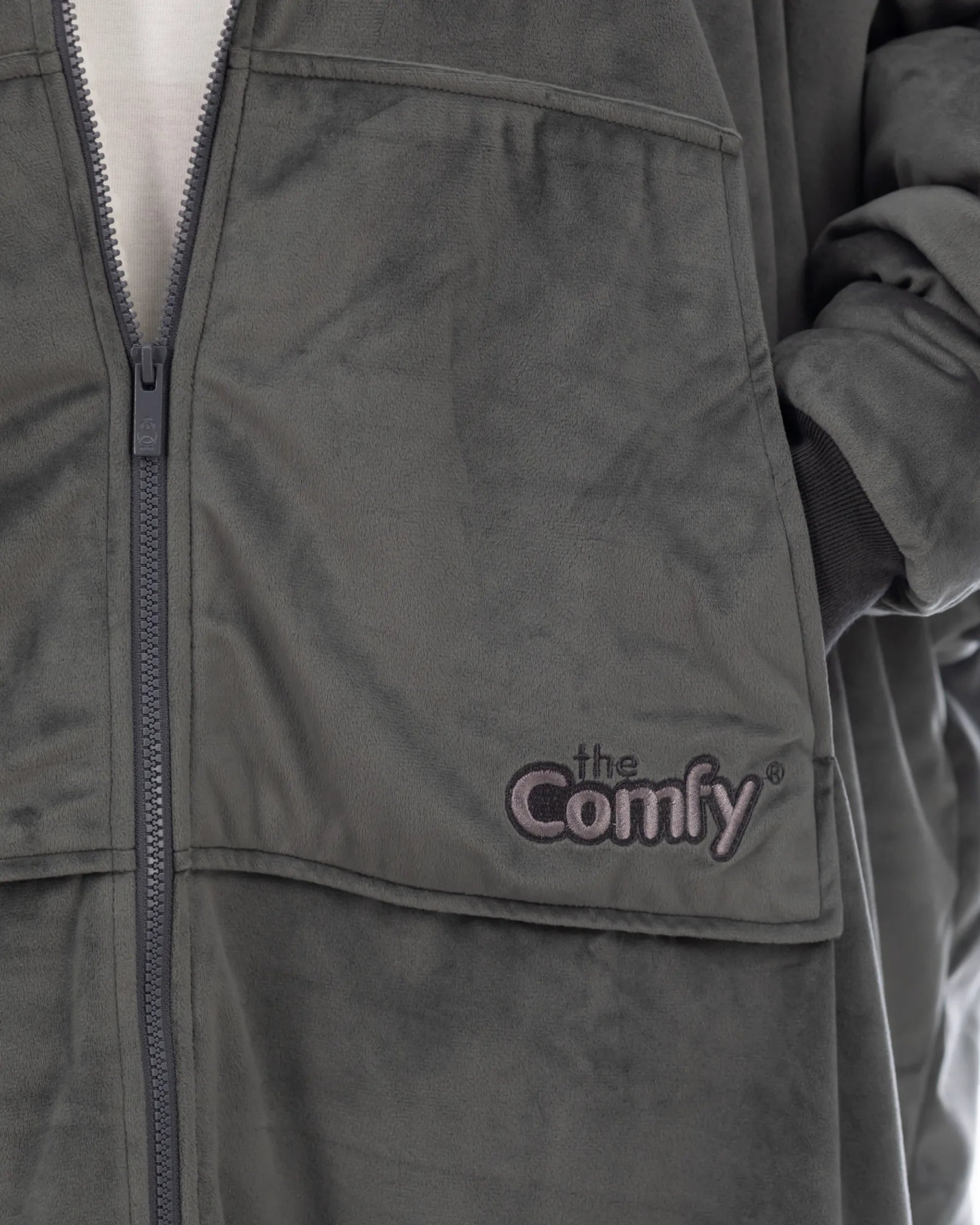 Close-up of The Original Full-Zip wearable blanket in charcoal showing zipper detail, Velveluxe™ exterior, and embroidered logo