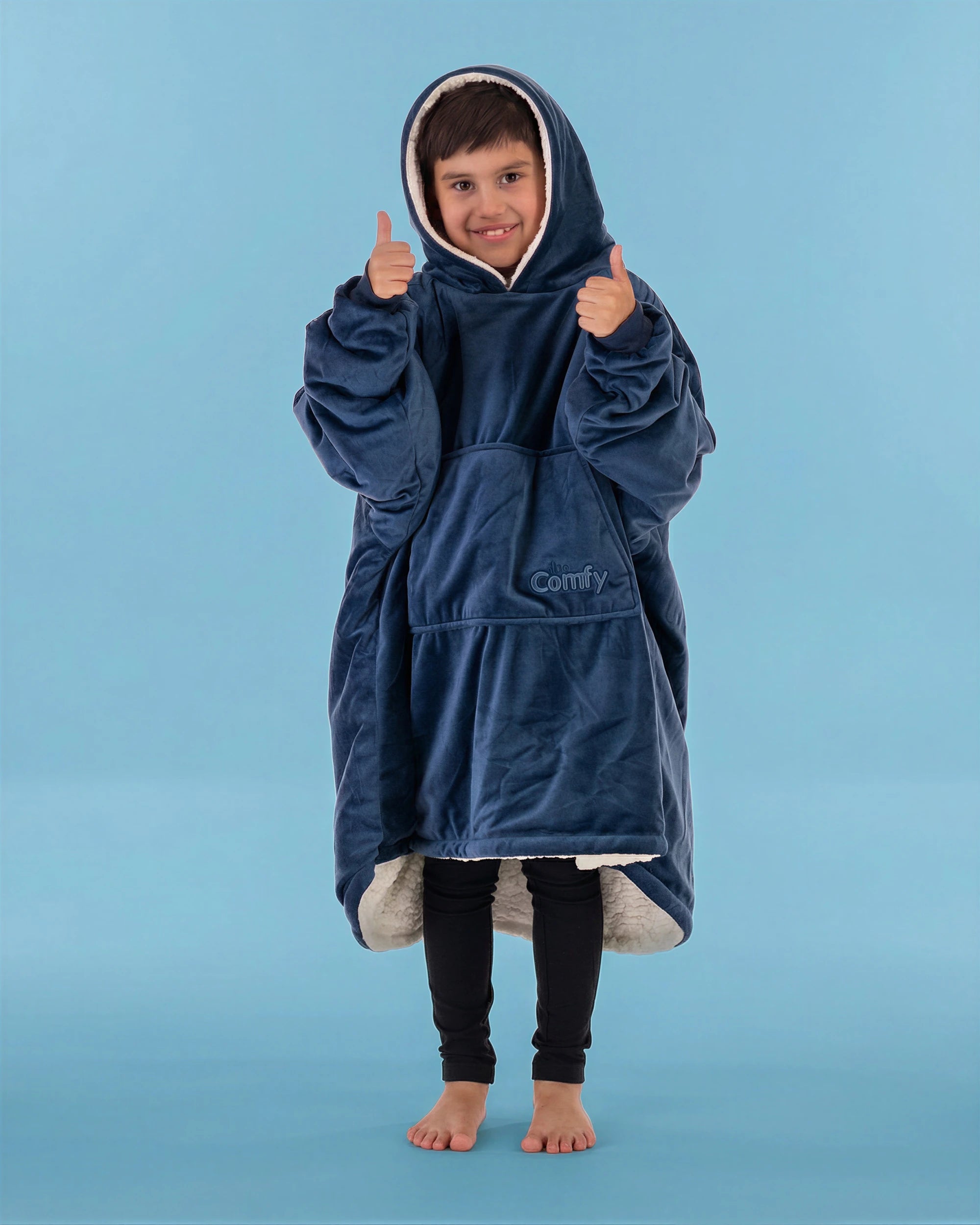 Child wearing The Original Jr. Blue wearable blanket with hood up and thumbs raised, showcasing all-day comfort and a cozy fit.