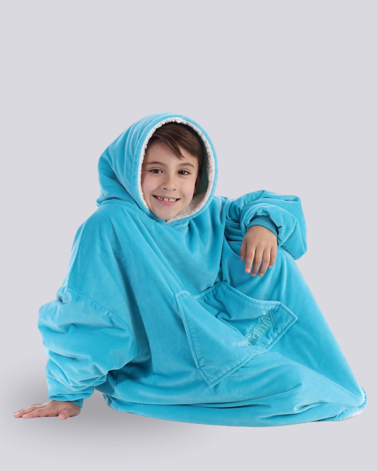The Original Jr wearable blanket in Neon Aqua, with model sitting down with legs tucked inside.