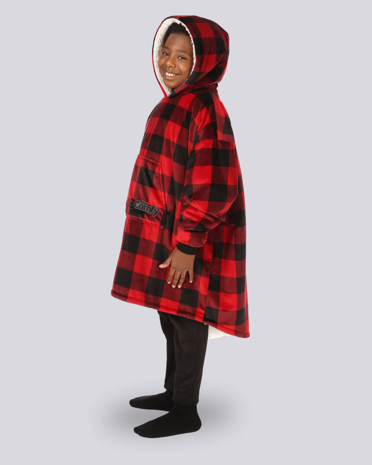 Child wearing The Original Jr. Red Plaid wearable blanket showing the side view of the oversized blanket hoodie.