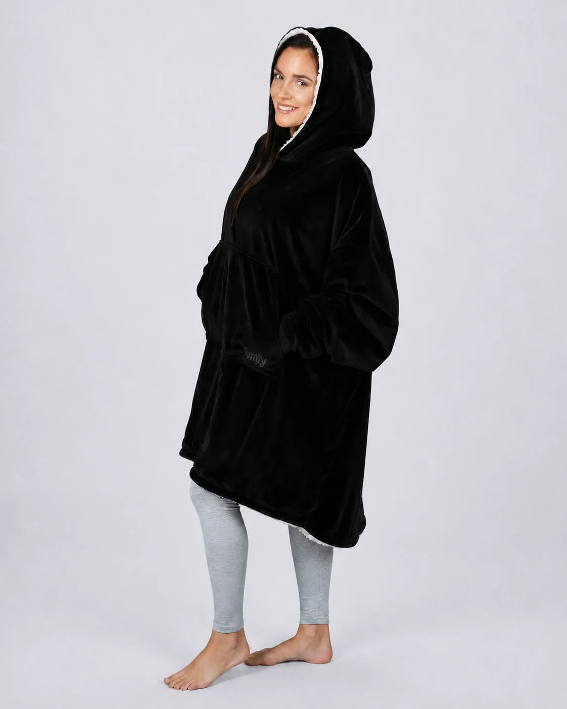 Side view of The Original wearable blanket in black showing oversized fit and hood design