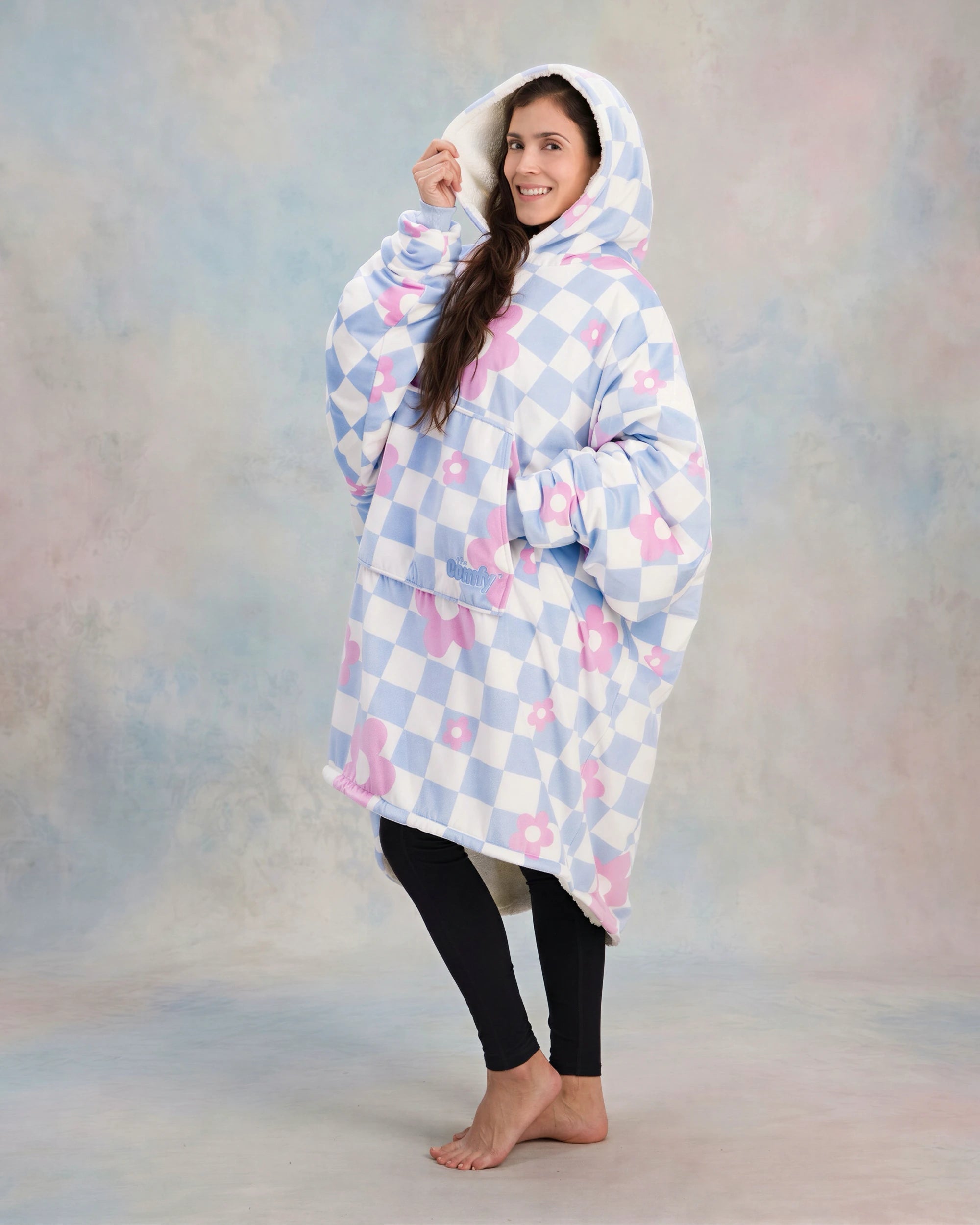 Side-angle lifestyle shot of The Original in Flower Checkered, highlighting the roomy hood, oversized fit, and ultra-soft Velveluxe™ exterior with all-over floral checkerboard print.