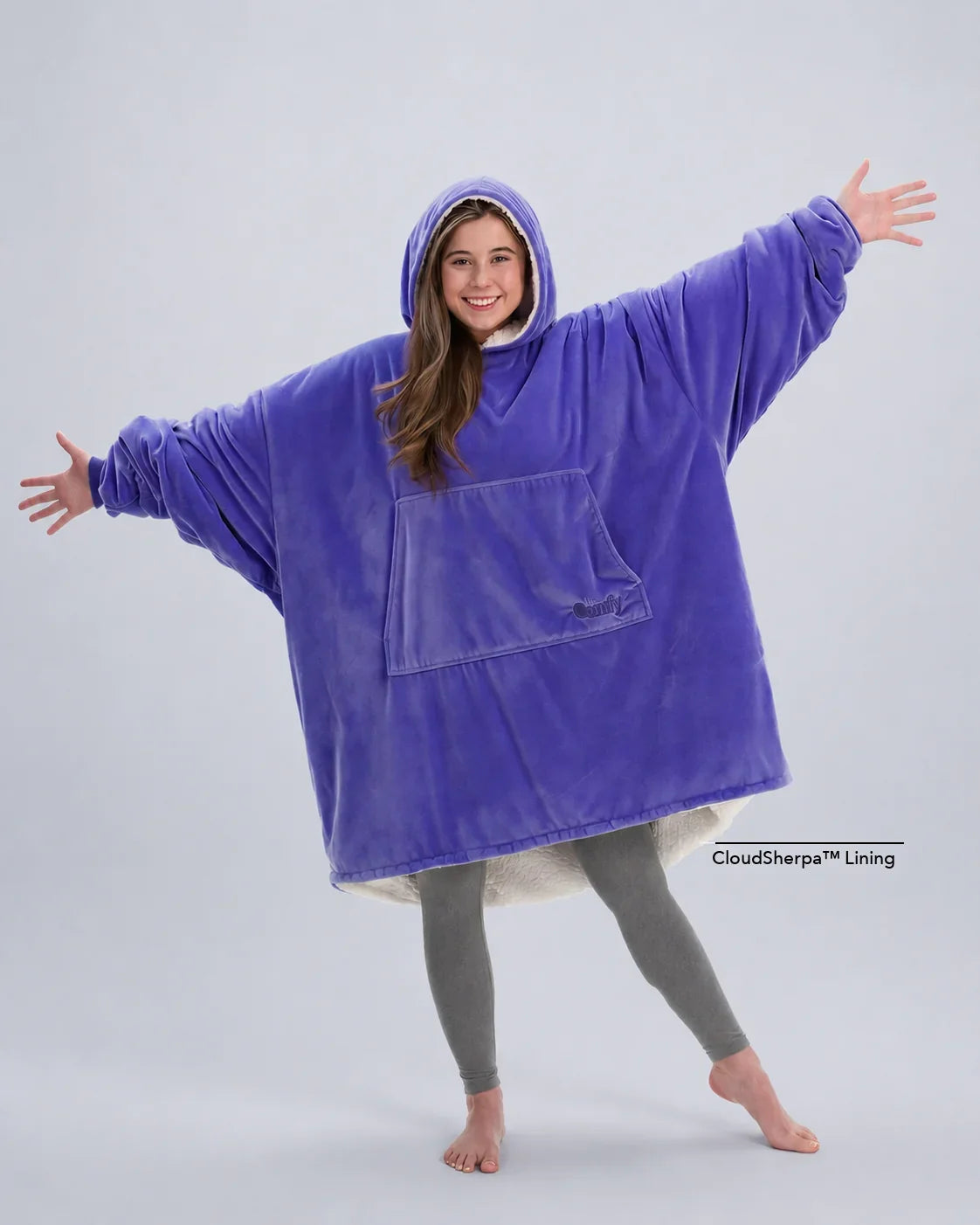 Model wearing The Original in Very Perri Purple with arms outstretched, showcasing the oversized wearable blanket silhouette, kangaroo pocket, and signature CloudSherpa™ lining for maximum comfort and coverage.