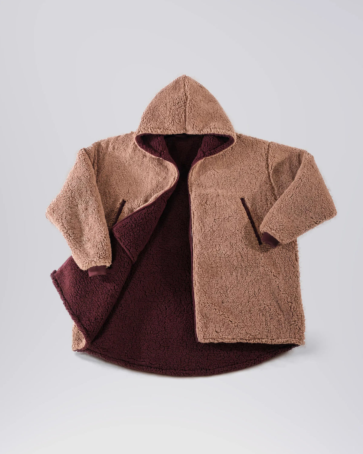 Product flat lay of the Teddy Bear Full-Zip in Camel, highlighting the all-over CloudSherpa™ texture, hood, full-length zipper, and reversible construction.