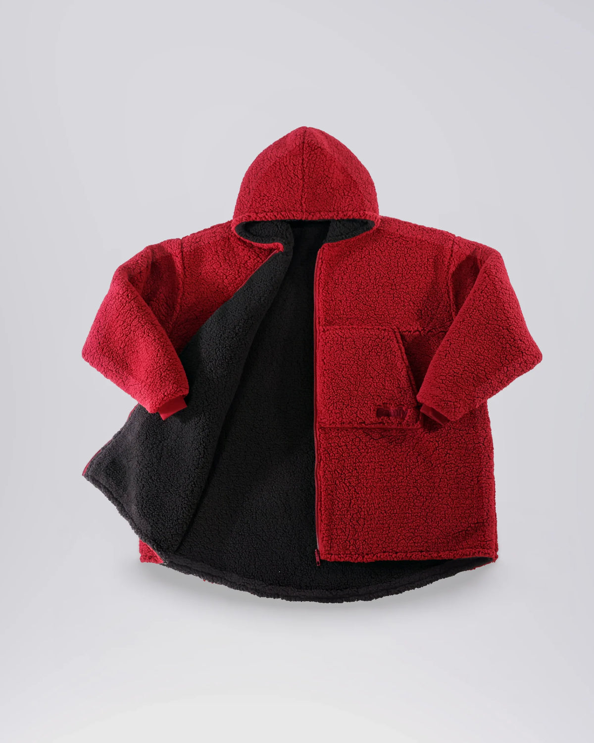 Flat lay of The Teddy Bear Full-Zip on its Crimson side, showing the hood, full-length zipper, and plush CloudSherpa™ fabric.