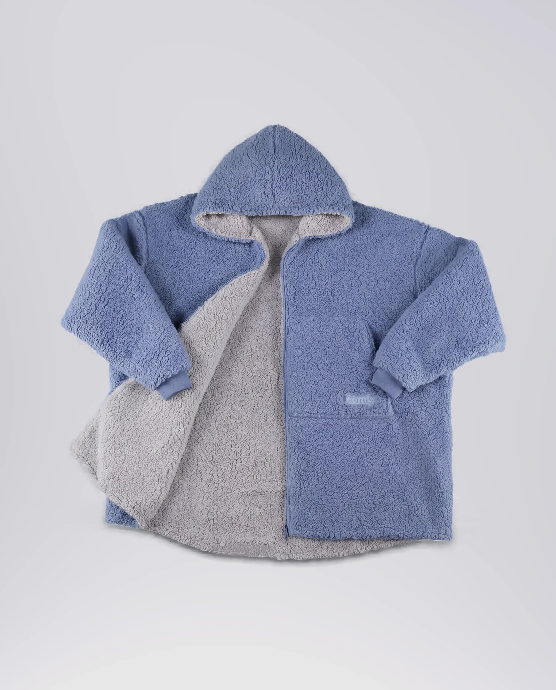 Product flat lay of the Teddy Bear Full-Zip in Denim, featuring reversible double-layer CloudSherpa™, an oversized hood, and full-length zipper.