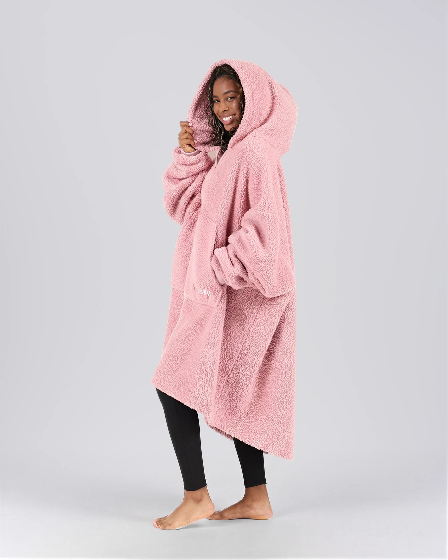 Side view of The Teddy Bear Quarter-Zip wearable blanket in blush highlighting relaxed drape, hood, and plush CloudSherpa™ texture