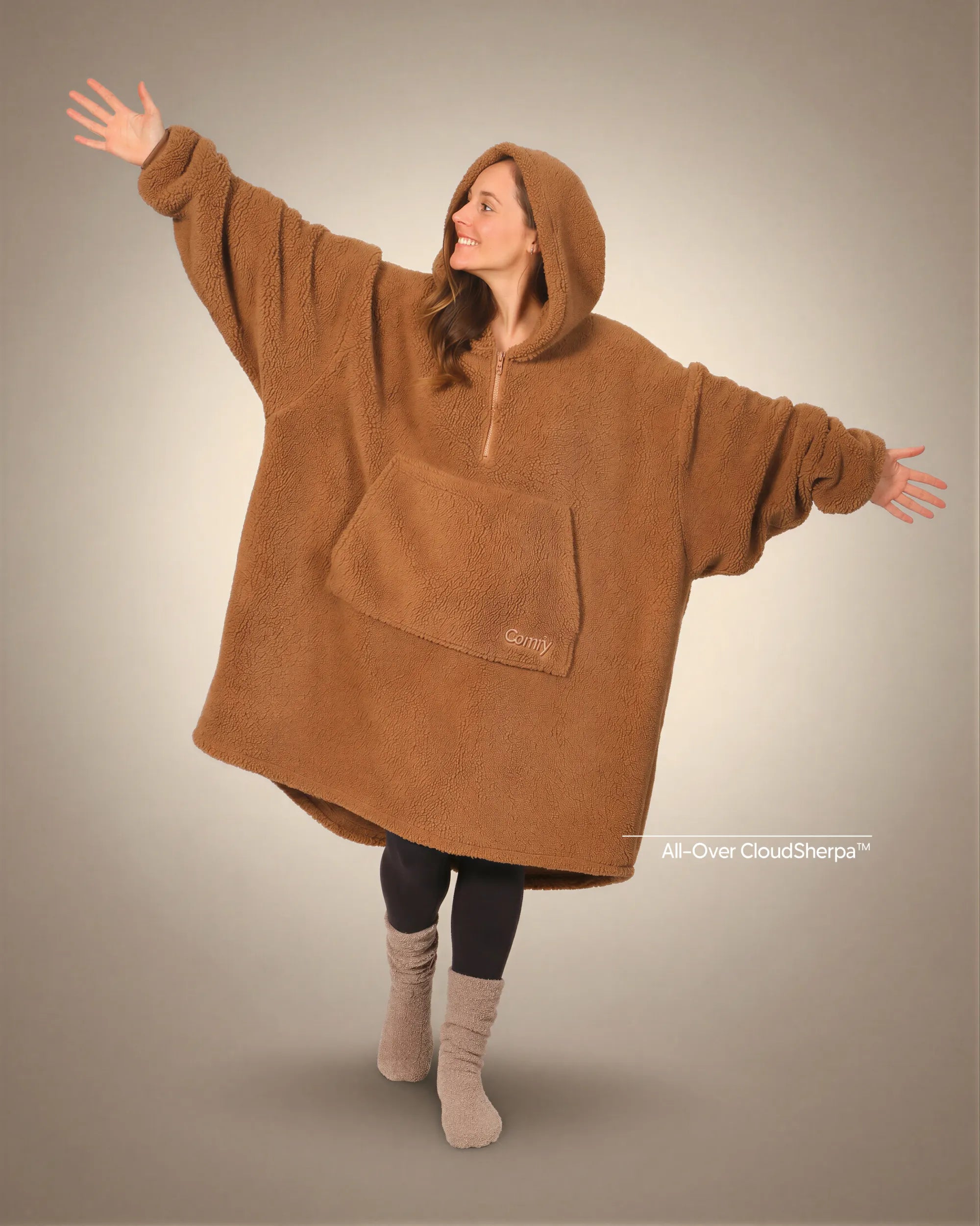 Front view of The Teddy Bear Quarter-Zip wearable blanket in camel showing oversized fit and all-over CloudSherpa™ fabric with hood up and arms extended