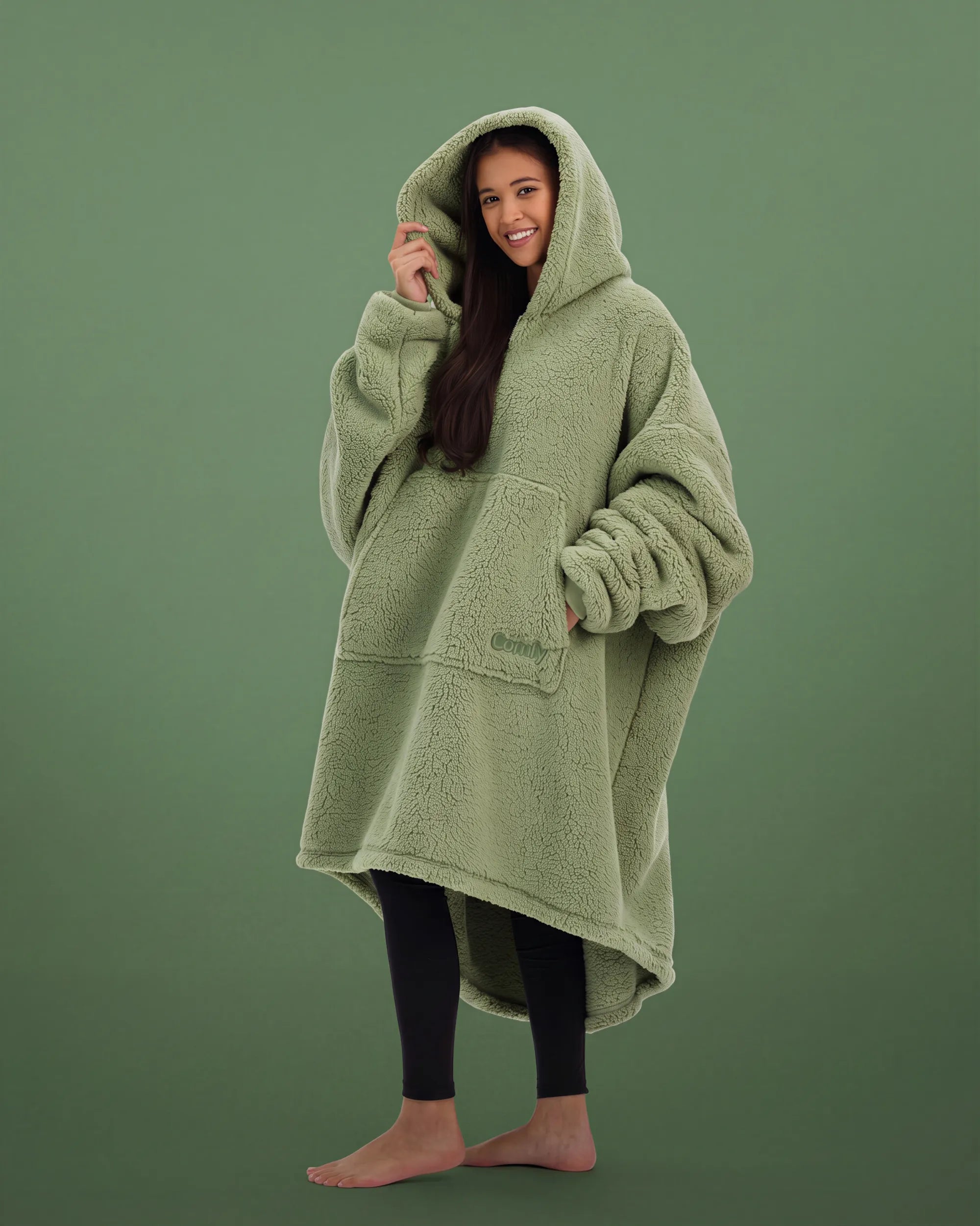 Three-quarter view of The Teddy Bear Quarter-Zip wearable blanket in cucumber highlighting relaxed drape, hood, and plush CloudSherpa™ texture