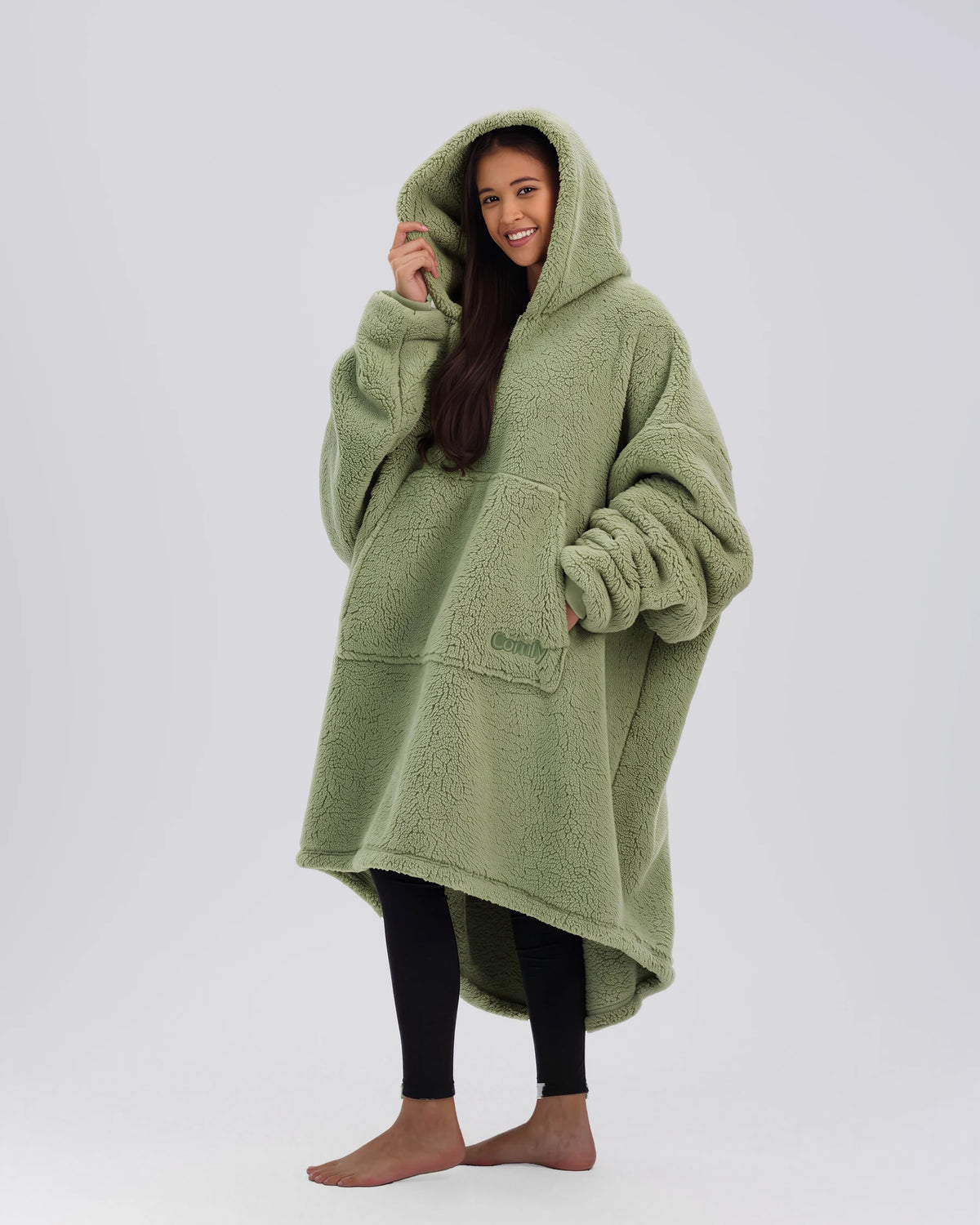 Three-quarter view of The Teddy Bear Quarter-Zip wearable blanket in cucumber highlighting relaxed drape, hood, and plush CloudSherpa™ texture