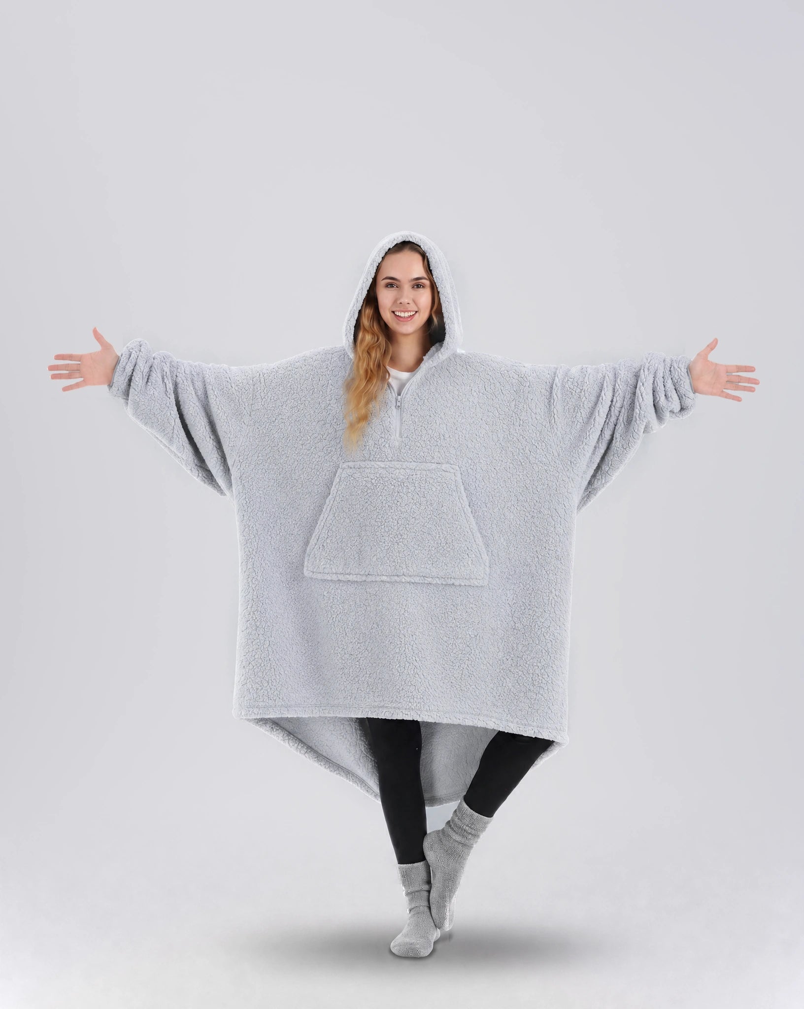 Front view of The Teddy Bear Quarter-Zip wearable blanket in light gray showing oversized fit and all-over CloudSherpa™ fabric with hood up and arms extended