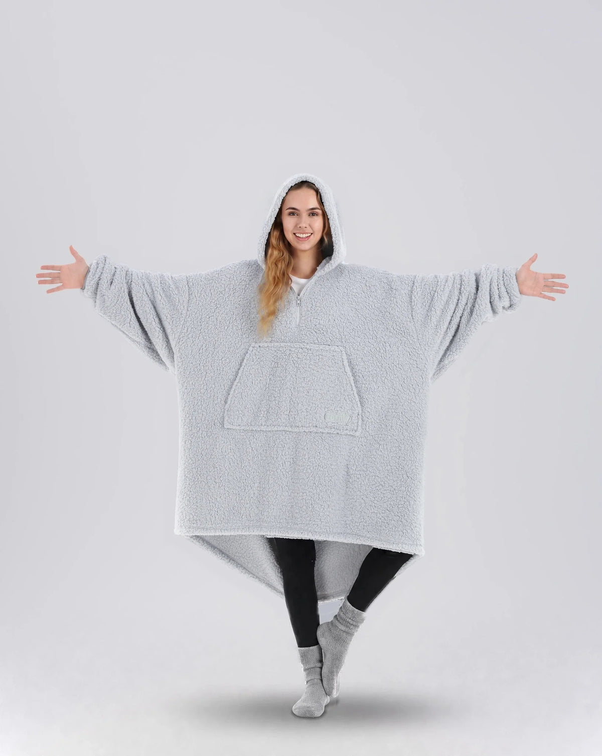 Front view of The Teddy Bear Quarter-Zip wearable blanket in light gray showing oversized fit and all-over CloudSherpa™ fabric with hood up and arms extended
