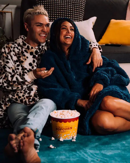 man and woman watching a movie and eating popcorn