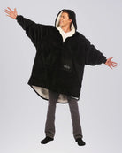 The Original Quarter-Zip wearable blanket in Black, front view with arms extended.