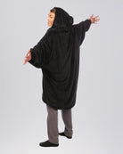 The Original Quarter-Zip wearable blanket in Black, rear view with arms extended.