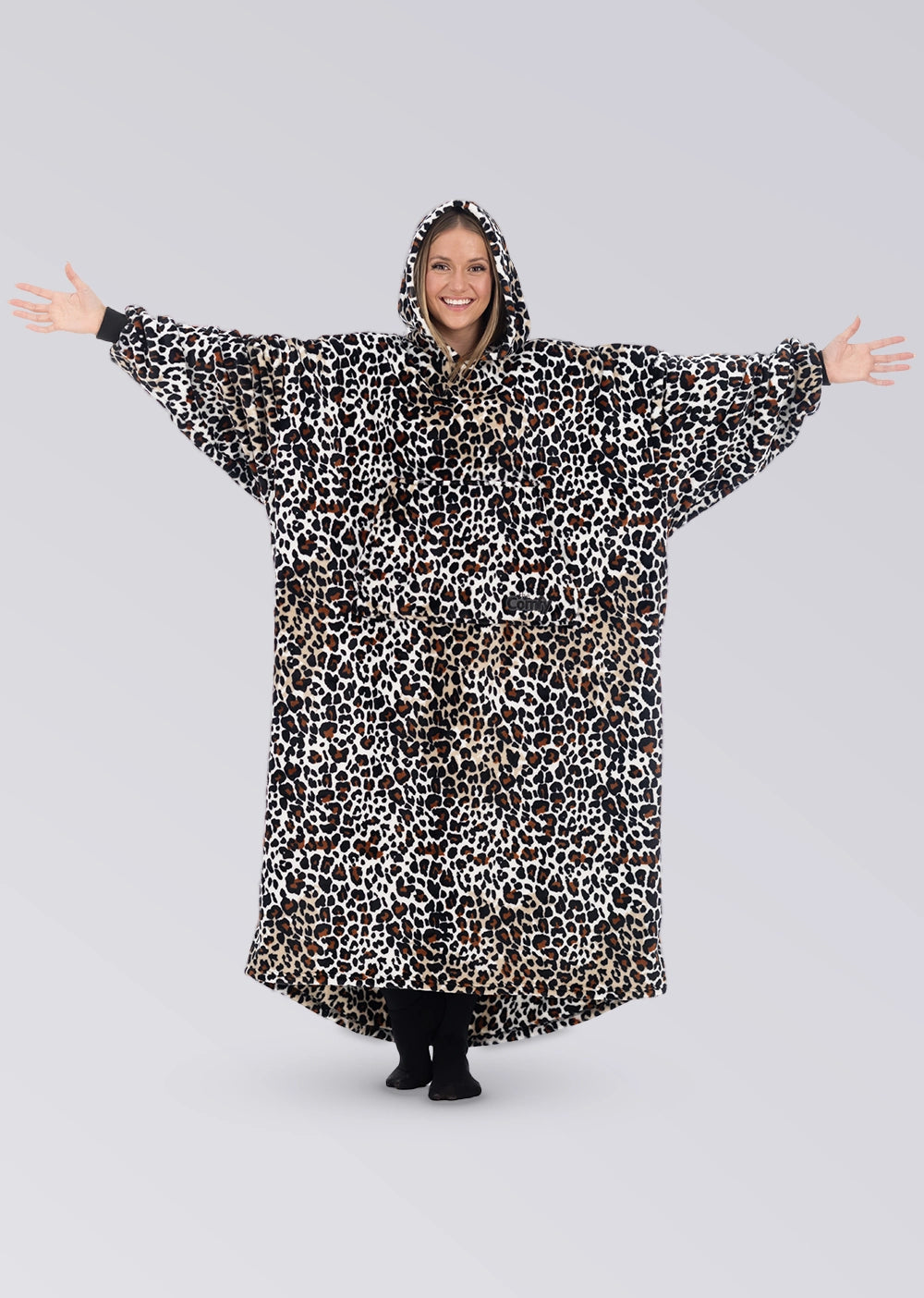 Woman standing with her arms out in The Dream Long in Leopard, showing the full-length silhouette and oversized sleeves.