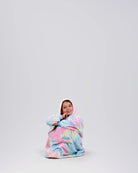 Child sitting comfortably in The Dream Jr. in Cotton Candy Tie Dye, showing its soft drape and relaxed fit.