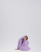 Child sitting comfortably in The Dream Jr. in Heather Purple, showing its soft drape and relaxed fit.
