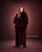 Woman standing in The Dream Long wearable blanket in Burgundy, showcasing the floor-length design and oversized fit.
