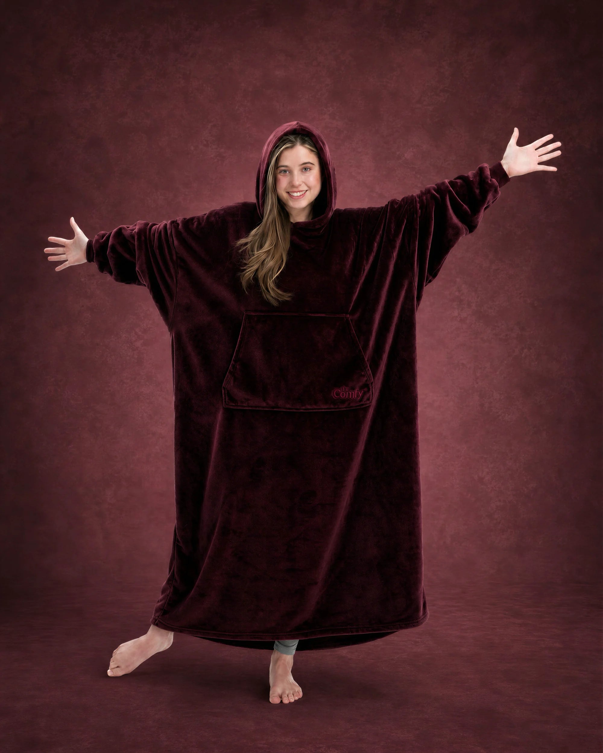 Woman with arms outstretched wearing The Dream Long in Burgundy, highlighting the oversized silhouette and full coverage.