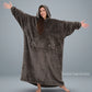 Woman standing with arms outstretched in The Dream Long wearable blanket in Dark Gray, showcasing the full-length silhouette and lightweight DreamHaven™ single-layer softness.