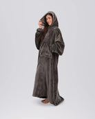 Side view of a woman wearing The Dream Long in Dark Gray with the oversized hood up.