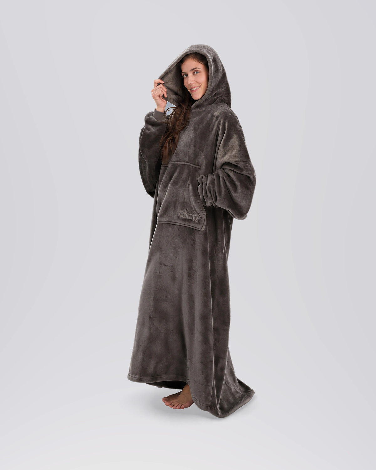 Side view of a woman wearing The Dream Long in Dark Gray with the oversized hood up.
