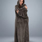 Woman wrapped comfortably in The Dream Long wearable blanket, emphasizing the extended length, oversized sleeves, and lightweight comfort for relaxing at home.