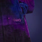 Close-up of The Dream Long in Galaxy featuring the soft microfiber fabric, embroidered The Comfy logo, and star-filled cosmic print.