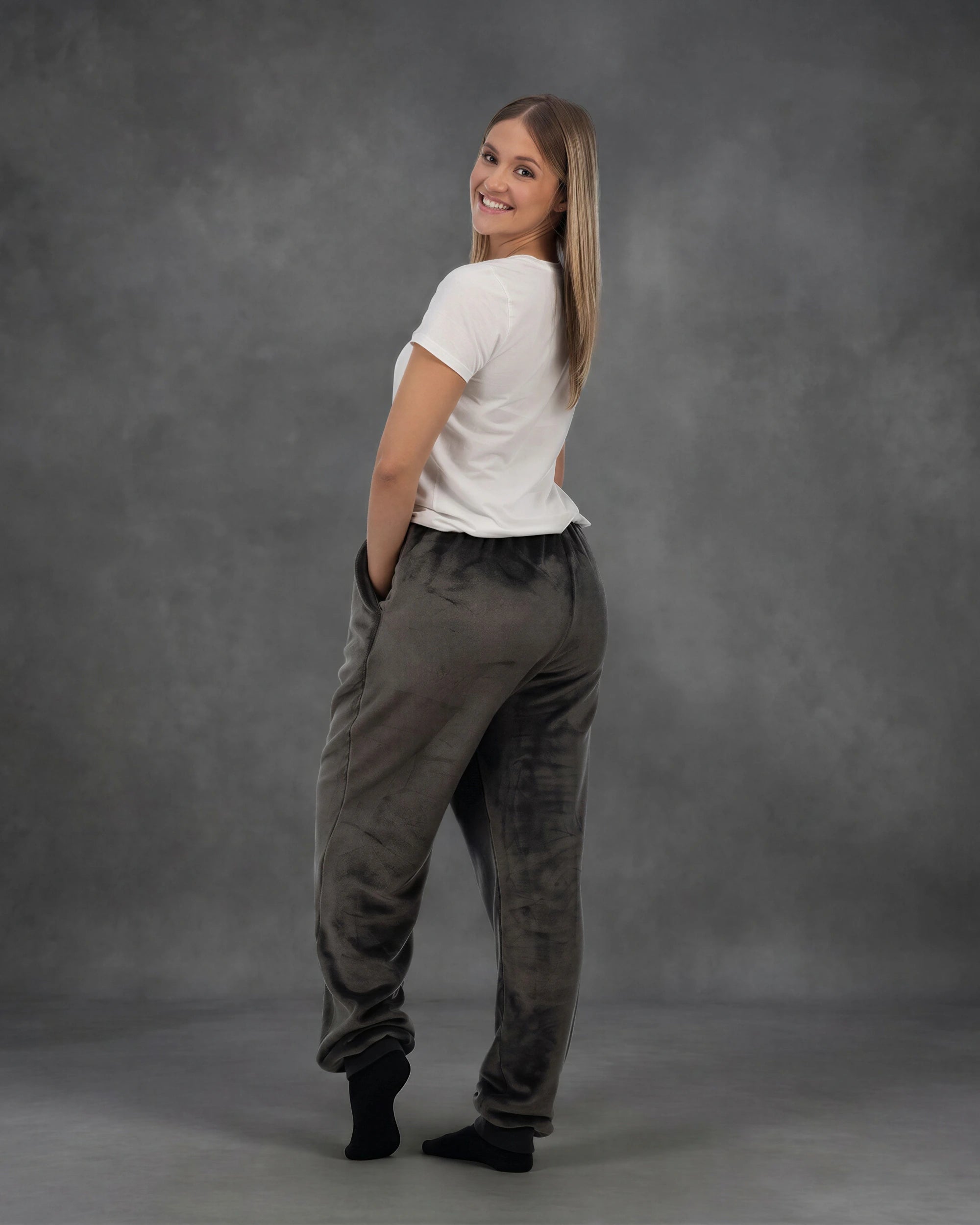 Rear three-quarter view of a woman wearing Dream Pants in Dark Gray, showcasing the relaxed silhouette and ultra-soft fabric.
