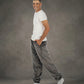Man wearing Dream Pants in Dark Gray in side profile, showcasing the relaxed fit, side pockets, and tapered leg design.