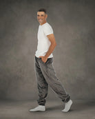 Man wearing Dream Pants in Dark Gray in side profile, showcasing the relaxed fit, side pockets, and tapered leg design.