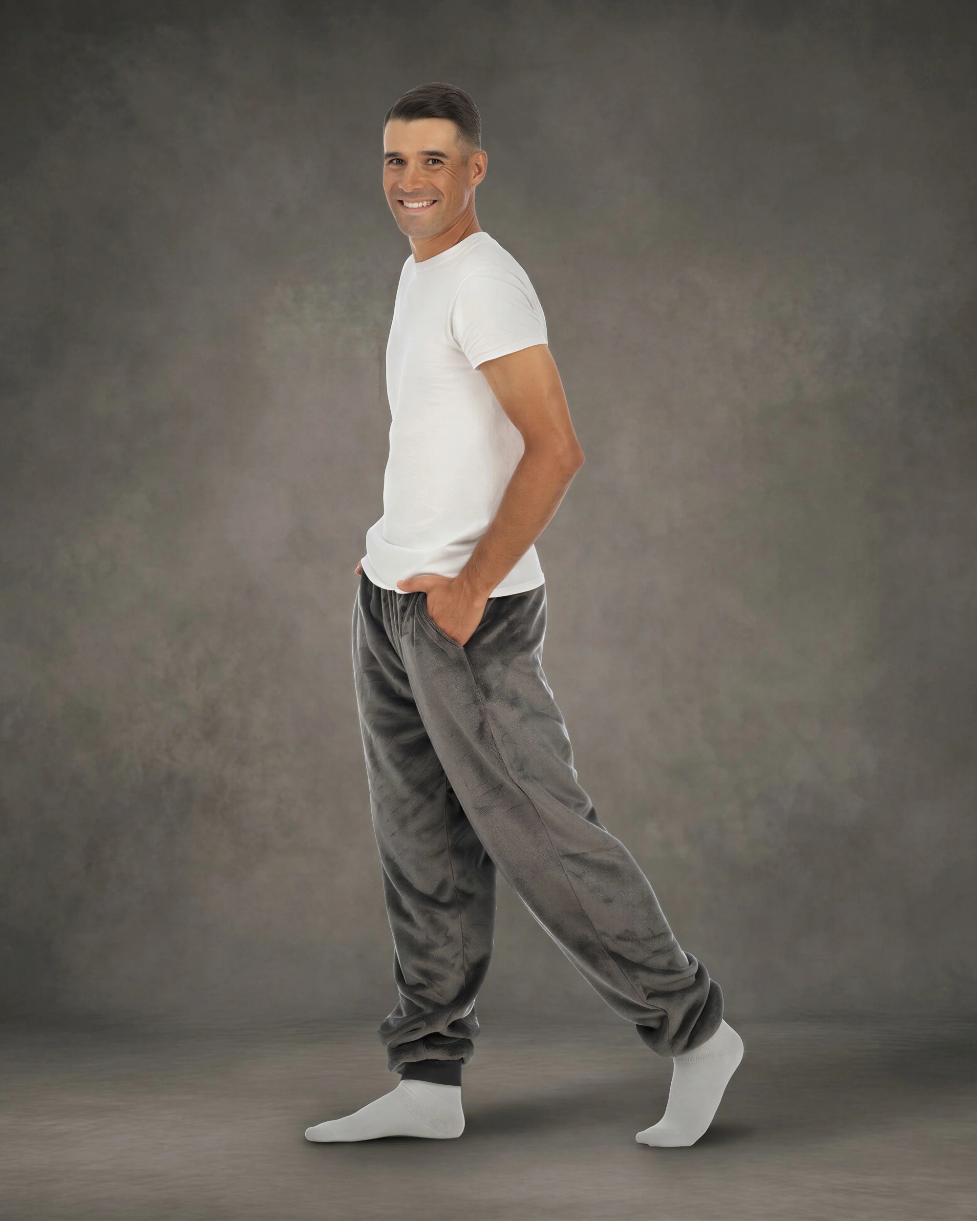 Man wearing Dream Pants in Dark Gray in side profile, showcasing the relaxed fit, side pockets, and tapered leg design.