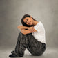 Woman sitting comfortably in Dream Pants in Dark Gray, highlighting the plush Dream fabric and cozy loungewear comfort.