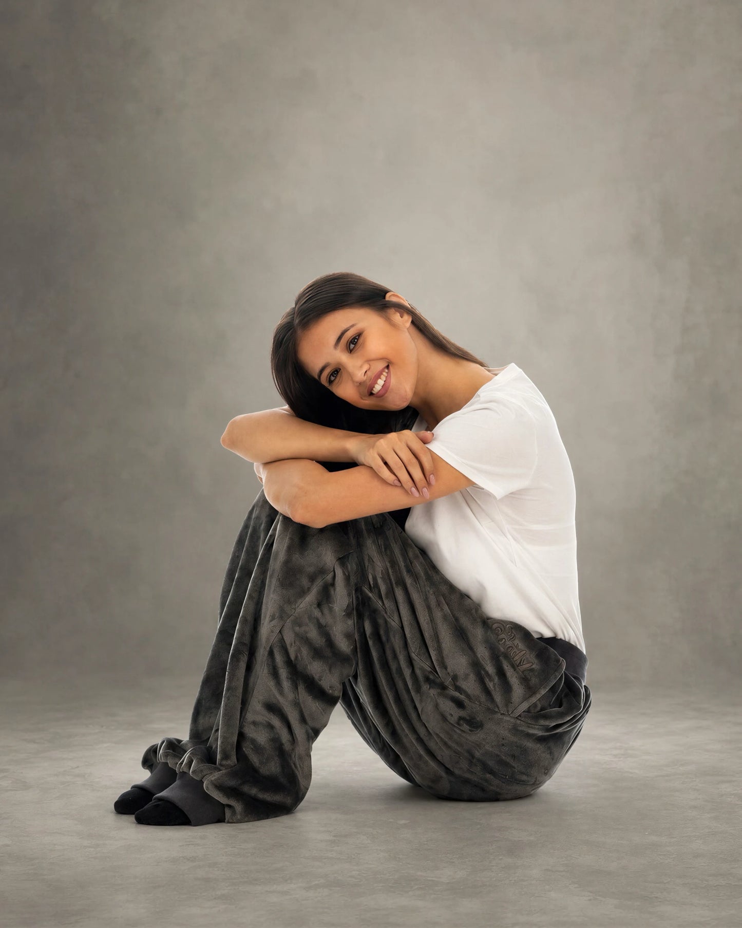 Woman sitting comfortably in Dream Pants in Dark Gray, highlighting the plush Dream fabric and cozy loungewear comfort.