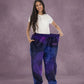 Woman stretching the waistband of Dream Pants in Galaxy, highlighting the comfortable fit and celestial-inspired print.