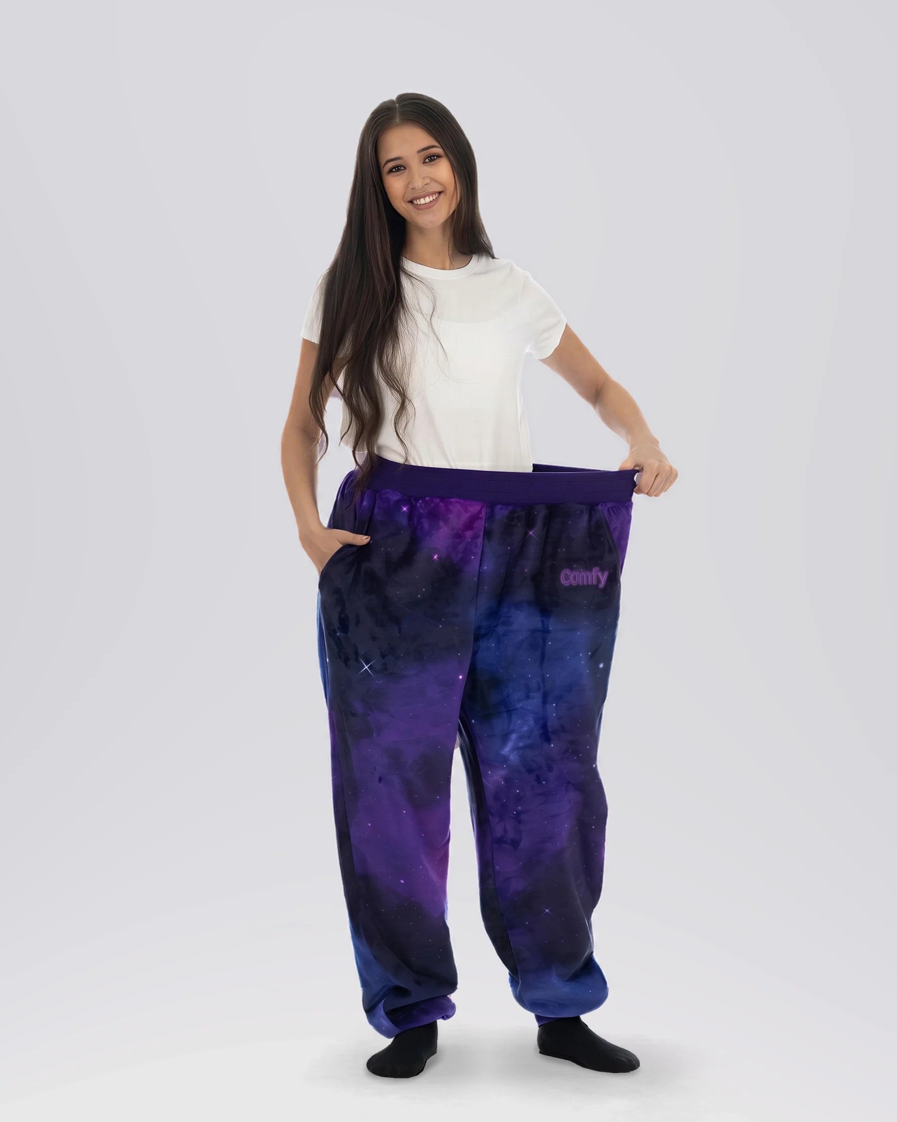 Woman stretching the waistband of Dream Pants in Galaxy, highlighting the comfortable fit and celestial-inspired print.