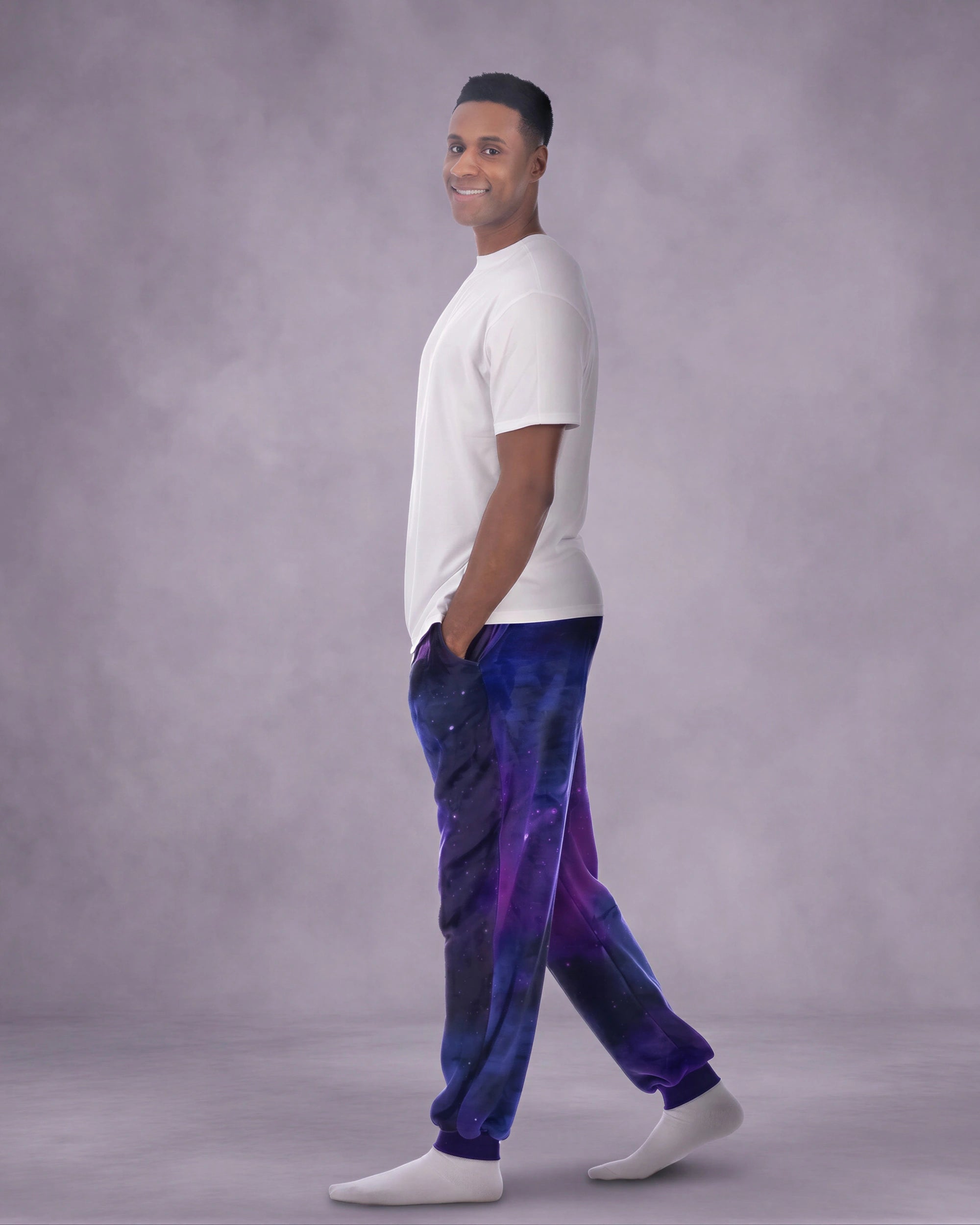 Man wearing Dream Pants in Galaxy in side profile, showcasing the relaxed silhouette, cuffed ankles, and galaxy print design.