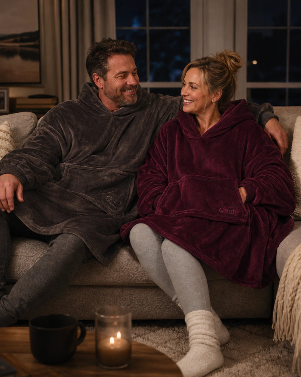 Man and woman on the couch wearing the dream in dark gray and burgundy.