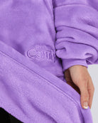 Close-up of The Dream in purple showing its fabric and embroidered logo.